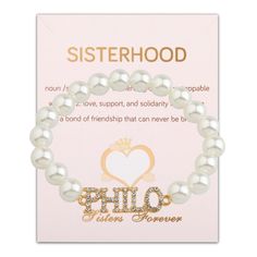 a bracelet with the words sisterhood written in gold on it and two pearls attached to it