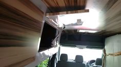 the inside of an rv with wood paneling on the ceiling and television mounted to the wall