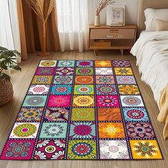 a colorful area rug with many different colors and designs on the floor in front of a bed