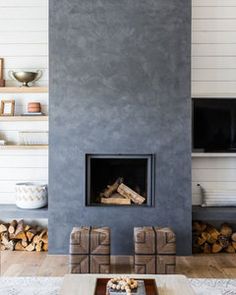 a living room filled with furniture and a fire place next to a wall mounted tv