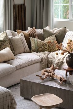 a living room filled with lots of furniture and pillows on top of a wooden table