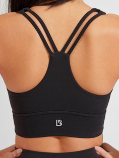 The Bloom Sports Bra is a long-line sports bra with a flattering sweetheart neckline and a light to medium level of support to highlight your best features. It has thick front straps leading to a strappy back and a subtle sinch between the cups. This bra is made with our signature NuBre fabric for a soft, second skin feel with high stretch retention. Fitted Yoga Bra With Built-in Padding, Fitted Sports Bra With Built-in Bra And Cross Back, Fitted Racerback Bra With Built-in Padding, Black Stretch Bra With Built-in Padding, Padded Nylon Sports Bra With High Stretch, High Stretch Padded Nylon Sports Bra, Black Cross Back Activewear With Built-in Padding, Fitted Activewear With Built-in Padding And Tank Straps, Fitted Strappy Nylon Sports Bra