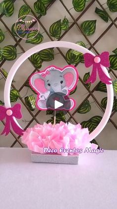 a cake topper in the shape of a mouse with pink flowers and bow on it