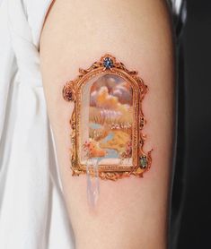 a woman's arm with a painting on it and an ornate frame around the arm