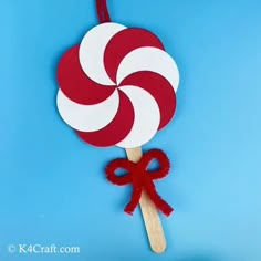 a red and white lollipop on a stick