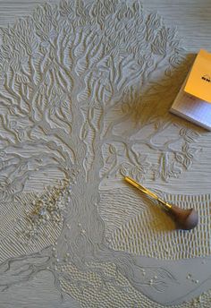 a pen and paintbrush sitting on top of a table next to a drawing tree