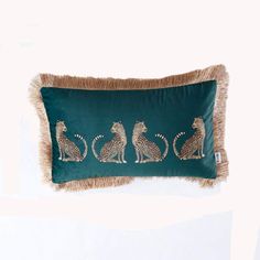 a green pillow with three cheetah sitting on it's sides and one standing up