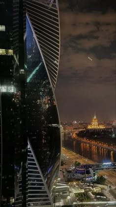 an aerial view of a city at night from the top of a tall building with lights on