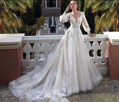 a woman in a wedding dress standing on a balcony with her hand on her head