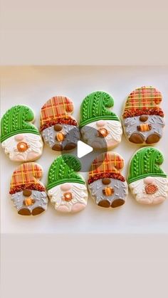 decorated cookies in the shape of santa's hats and beards are arranged on a white surface