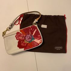 Coach White Leather Handbag With Beautiful, Colorful Flower. Comes With Original Protective Bag. Never Used. Coach Clutch With Removable Pouch, Designer Bags With Zipper Pouch For Gifts, Designer Bags With Zipper Pouch As Gift, Coach Bags With Removable Pouch As Gift, Coach Multicolor Clutch Bag, Multicolor Coach Clutch Bag, White Clutch Pouch With Dust Bag, Chic Coach Bag With Zipper Pouch, Spring Coach Pouch Bag