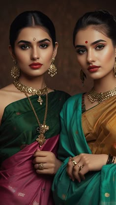 two women in sari are posing for the camera