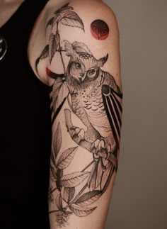 an owl on a tree branch with leaves around it's neck and shoulder tattoo