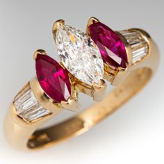 This elegant ring is centered with one (1) marquise brilliant cut diamond set into a two-prong setting. The center stone is flanked to each side by one (1), prong set, marquise mixed cut natural ruby. The shoulders of the ring are each accented with three (3), channel set, baguette cut diamonds. The ring measures 9.3mm at the top, rises 6.2mm above the finger, tapering to 2.3mm wide and 1.0mm thick at the base of the shank. This ring is currently a size 5.25. Diamond Ring With Ruby Accents, Classic Marquise Ruby Ring With Brilliant Cut, Classic Marquise Ruby Ring With Vvs Clarity, Classic Marquise Ruby Ring With Center Stone, Marquise Cut Ruby Diamond Ring With Prong Setting, Anniversary Ruby Ring With Marquise Cut Center Stone, Marquise Ruby Ring With Center Stone, Marquise Cut Ruby Ring With Center Stone For Anniversary, Anniversary Marquise Ruby Ring With Center Stone