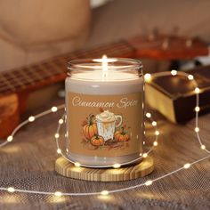 a candle that is sitting on a table next to some string lights and a guitar