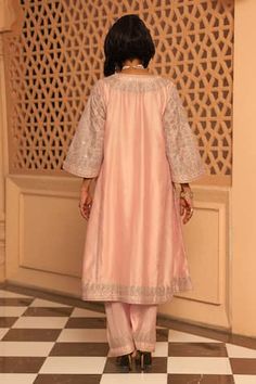 Rose pink chauga kurta featuring notched neck and three quarter sleeves with intricate Kashmiri tilla and mirror work embroidery. Paired with a matching salwar adorned with embroidered hem., Fit: Relaxed Pink Kurta For Eid Reception, Elegant Pink Sets For Transitional Season, Pink Cotton Silk Set For Reception, Pink Dabka Kurta For Reception, Elegant Pink Palazzo Set In Cotton Silk, Elegant Pink Cotton Silk Palazzo Set, Pink Resham Embroidered Art Silk Kurta, Elegant Pink Cotton Silk Sharara, Elegant Pink Palazzo Set With Cutdana