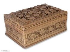 a carved wooden box with leaves and vines on it's lid is shown in front of a white background