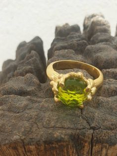 This is gold plated brass peridot ring. A designer handmade ring. It has a design of a coral, holding a green peridot gem. It could be an alternative engagement ring, or a great gift for a loving one. - 14 karat Gold plated brass - Round peridot gem - Free shipping worldwide - Sent in a gift box If you would like to see other rings I have made, please follow this link: https://www.etsy.com/il-en/shop/TamyZurTachshit?ref=seller-platform-mcnav&section_id=17271018 If you would like to go back t Green Gemstone Ring Gold-plated, Green Gemstone Gold Plated Rings, Green Gold Plated Ring, Green Gold-plated Ring, Gold Plated Green Rings For Gift, Green Gold Plated Rings For Gift, Elegant Handmade Peridot Rings, Handmade Elegant Peridot Rings, Unique Green Peridot Rings