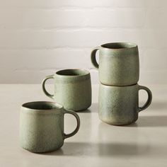 four green mugs stacked on top of each other