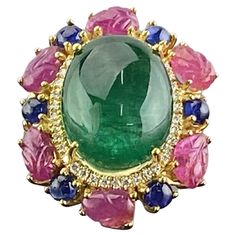 One of a kind art-deco inspired multi-gemstone tutti-frutti cocktail ring. A stunning 12.80 Zambian Emerald cabochon center stone (ideal vivid green color, transparent, great luster) surrounded with Diamonds, Burmese Ruby carvings, and Sapphires - all set in solid 18K Yellow Gold. The ring is currently sized at US 7, can be resized. We provide free shipping, and accept returns. Gem Rings Stones 1stdibs, Luxury Unique Round Gemstones, Luxury Multicolor Oval Gemstones, Fine Jewelry Multicolor Cabochon Gemstones, Multicolor Cabochon Gemstones Fine Jewelry, Multicolor Cabochon Gemstones For Fine Jewelry, Multicolor Cabochon Rings In Fine Jewelry Style, Multicolor Cabochon Rings Fine Jewelry, Luxury Multicolor Cabochon Rings