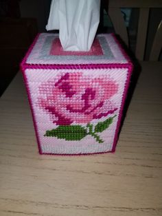 a pink tissue box sitting on top of a wooden table