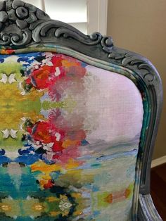 an upholstered chair with colorful flowers painted on it