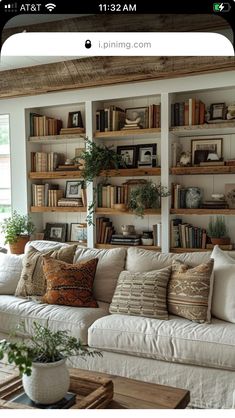 a living room filled with lots of furniture and bookshelves full of books on top of them