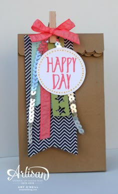 a brown bag with a happy day tag on the front and red ribbon around it