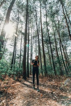 a woman standing in the middle of a forest