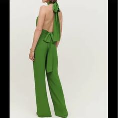 The Roland Is A Sleeveless, Full-Length Jumpsuit With A Halter Neck And Relaxed Legs. It Features An Open Back, Ties At The Neck And Waist, And Front Ruching. Up To 32” Waistline, 33” Inseam, 13” Trouser At Bottom - Fitted Waist - Full Length - Halter Neck - High Rise - Lined - Open Back - Relaxed Fit In Leg - Ruching On Bodice - Ties At Back Neck - Ties At Waist Green Sleeveless Jumpsuits And Rompers For Evening, Green Sleeveless Jumpsuits For Evening, Chic Green Evening Jumpsuits And Rompers, Elegant Green Backless Jumpsuits And Rompers, Elegant Green Backless Jumpsuit, Green Wide-leg Jumpsuits For Party, Green Wide Leg Jumpsuits And Rompers For Party, Green Wide Leg Jumpsuits For Party, Green Strapless Sleeveless Jumpsuit For Night Out