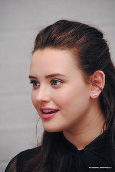 a close up of a person with a cell phone in her hand and wearing earrings