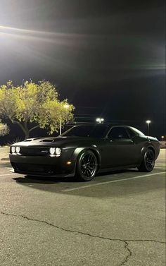 a black car parked in a parking lot at night