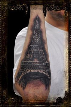 a man's arm with a tattoo of the eiffel tower