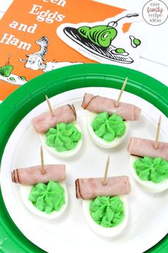 green eggs and ham are arranged on a paper plate with toothpicks in them