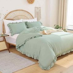 a bed with green sheets and pillows in a room