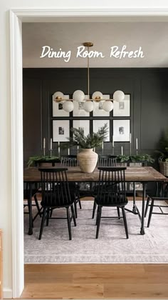 a dining room with black walls and wooden floors