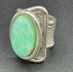 Introducing this most unusual and elegant Sterling Silver Ring with large Chrysoprase cabochon. Crafted with an eye for beautiful stones, this ring features the soothing colors of moss green and warm brown highlighted by a textured but simple sterling silver design.  The elegance and simplicity of this large ring is show stopping. The size is 10.5 so perfect for an index or middle finger. Whether you're dressing up for a special occasion or adding a touch of glamour to your everyday look, this r Unique Oval Cabochon Emerald Ring, Modern Green Cabochon Rings, Unique Green Cabochon Opal Ring, Unique Adjustable Green Opal Ring, Green Oval Modernist Jewelry, Green Modernist Oval Jewelry, Unique Chrysoprase Ring With Large Stone, Unique Cabochon Emerald Ring, Collectible, Unique Green Cabochon Ring