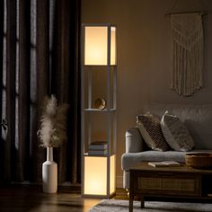 This 2-light floor lamp features a boxy, column silhouette that illuminates any room. Reminiscent of a clean-lined modern bookcase, it has a sleek frame made from engineered wood and plastic. Rectangular white fabric shades at the top and the bottom temper the light from two dimmable 40W max bulbs (sold separately). Our favorite perk? Two shelves in the center are just the right spot to hold books, decor, and more. At 61.5" tall and 10.25" square, this lamp is ideal for space-conscious areas aro Standing Lamp Living Room, Lamp With Shelves, Shelf Floor Lamp, Shelf Lamp, Lamp Making, Corner Floor Lamp, Bottom Light, Column Floor Lamp, Modern Floor Lamp