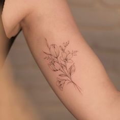 a woman's arm with a flower tattoo on the left side of her arm