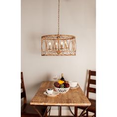 a wooden table topped with bowls of fruit under a chandelier hanging from the ceiling