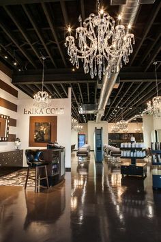 an empty room with chandeliers and tables in the center is lit by lights that are hanging from the ceiling