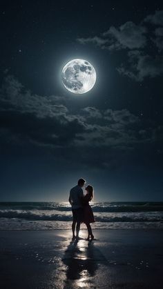 a man and woman standing on the beach under a full moon with their arms around each other