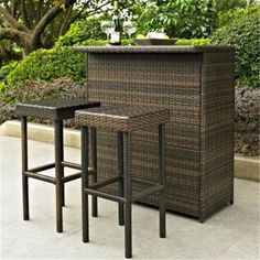 two brown wicker bar stools next to each other in front of a planter