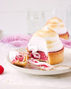 there is a dessert on the plate with whipped cream and raspberry toppings