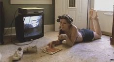 a woman laying on the floor in front of a tv