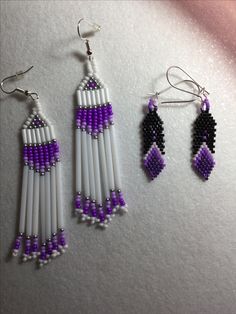 three pairs of beaded earrings are displayed on a white surface with purple and black beads