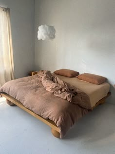 a bed sitting in the middle of a room next to a window with curtains on it