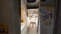 the interior of an rv is shown with white couches and tables in front of it