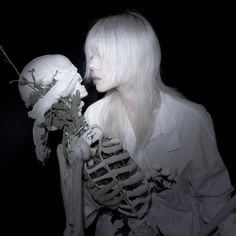 a woman with white hair holding a skeleton