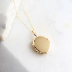 A stunning 9ct solid gold oval locket on a solid gold chain.This is a really special piece and an ideal present for those who prefer to wear only solid gold. Its great advantage is that it will not fade or tarnish and will remain as beautiful as ever. Like all our lockets it can hold 2 photos.Necklace comes on an 16" or 18" solid gold fine link chain.The locket, chain and fittings are made from 9ct solid gold. Please rub with a gold or lint free cloth to clean.Locket comes boxed in a Lime Tree D Oval Locket Necklace, Locket Chain, Chain Locket, Birmingham Jewellery Quarter, Lime Tree, Oval Locket, Gold Link Chain, Solid Gold Chains, Gold Locket